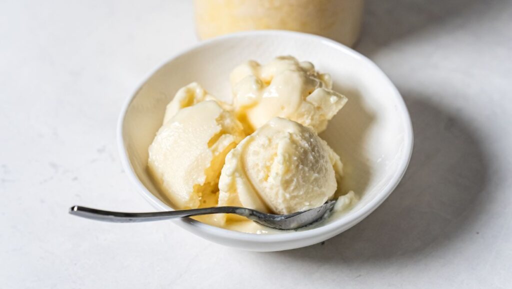 dole whip in a white bowl with a spoon.