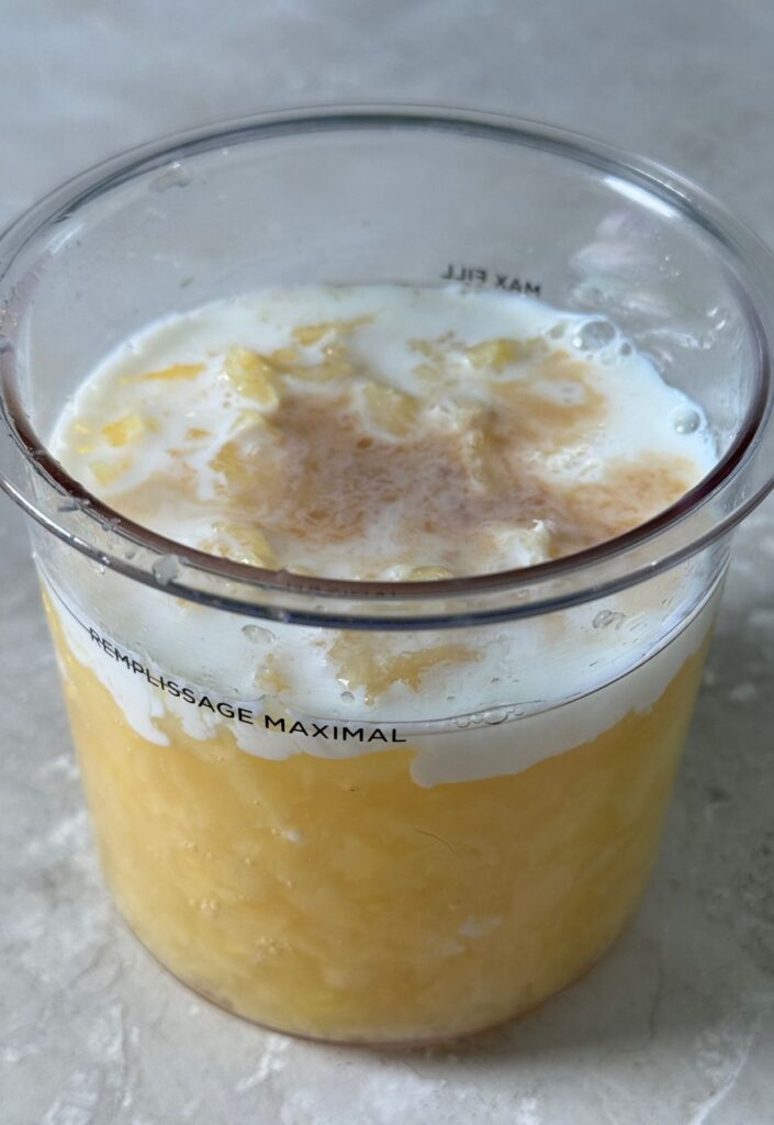 pineapple, milk and vanilla in a clear pint.