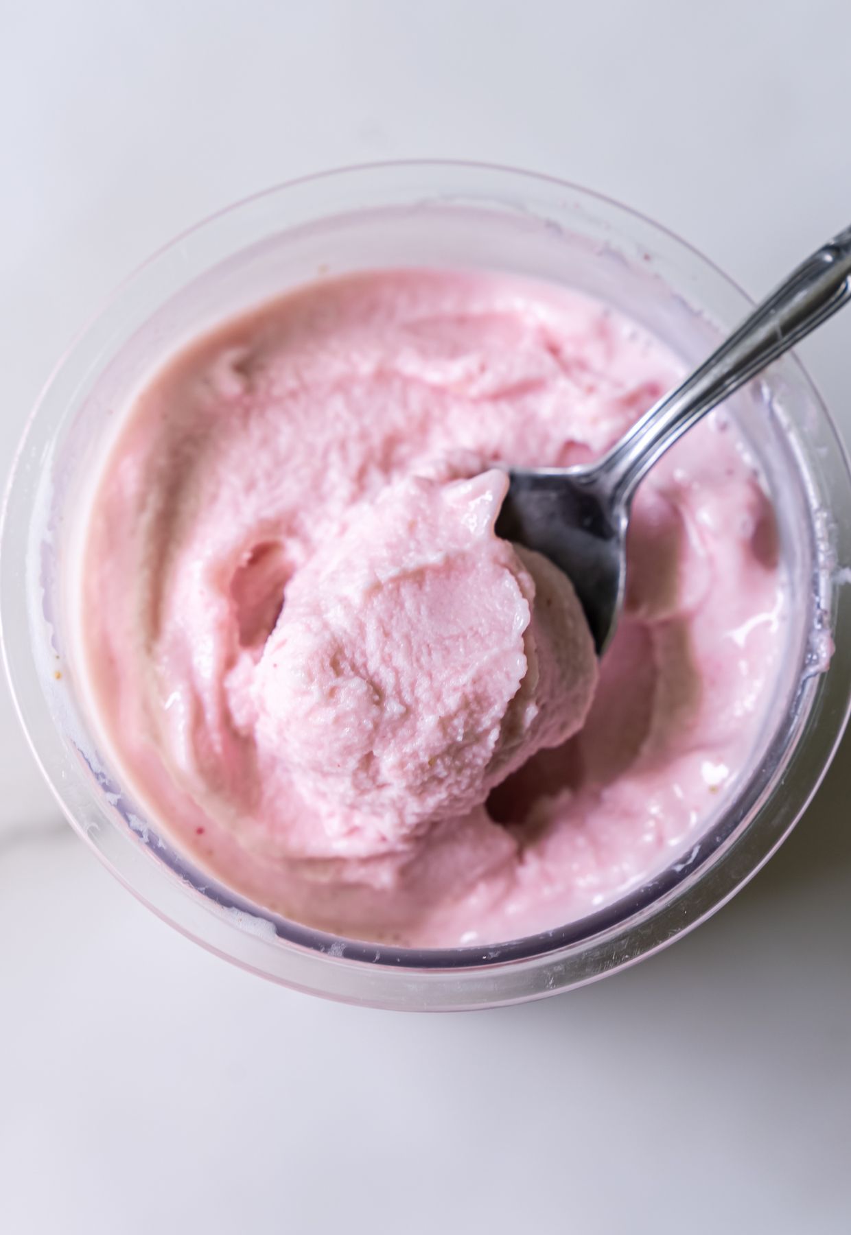 Ninja Creami strawberry ice cream in a pint container with spoon.