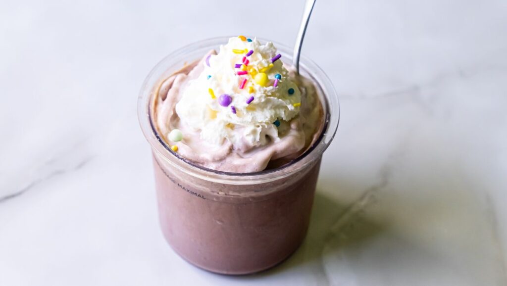 chocolate ice cream with whipped cream and sprinkles.