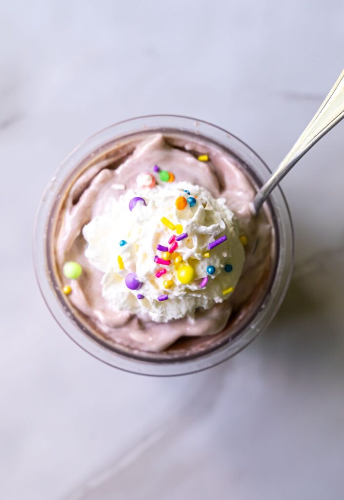chocolate ice cream with whipped cream and sprinkles.