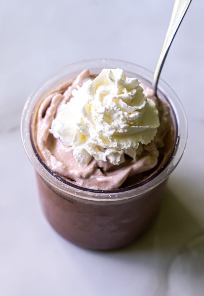 Chocolate high protein ice cream with whipped cream.