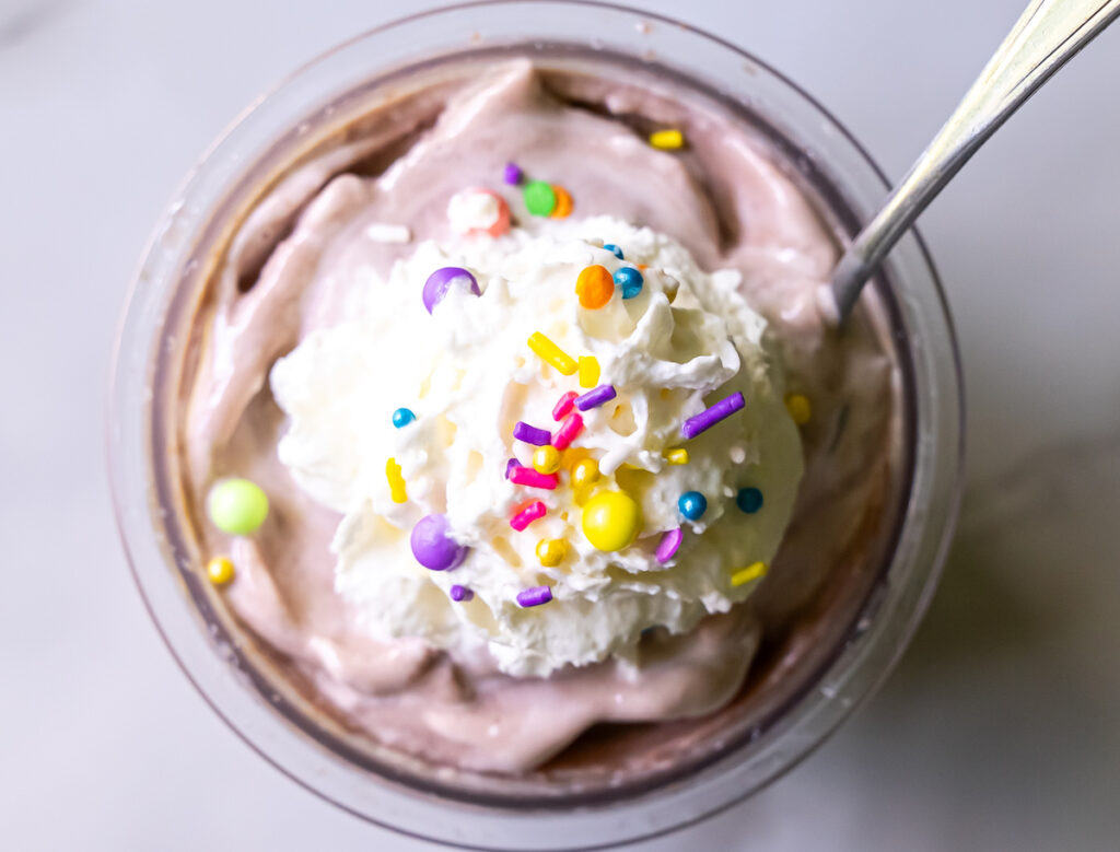 chocolate ice cream with whipped cream and sprinkles.