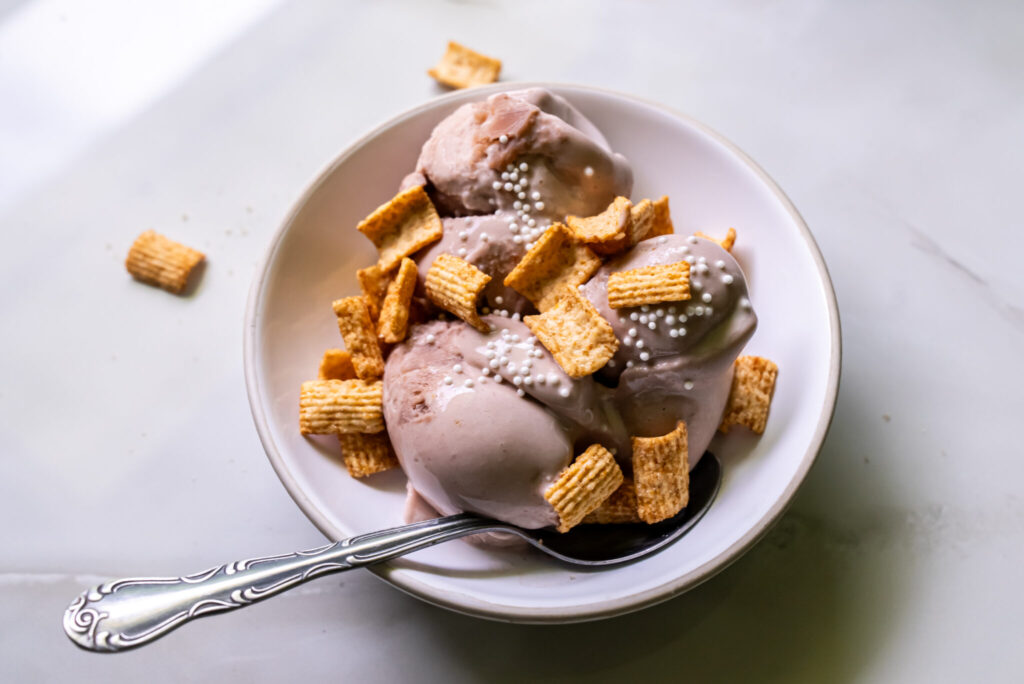 chocolate yogurt with toppings and a spoon.