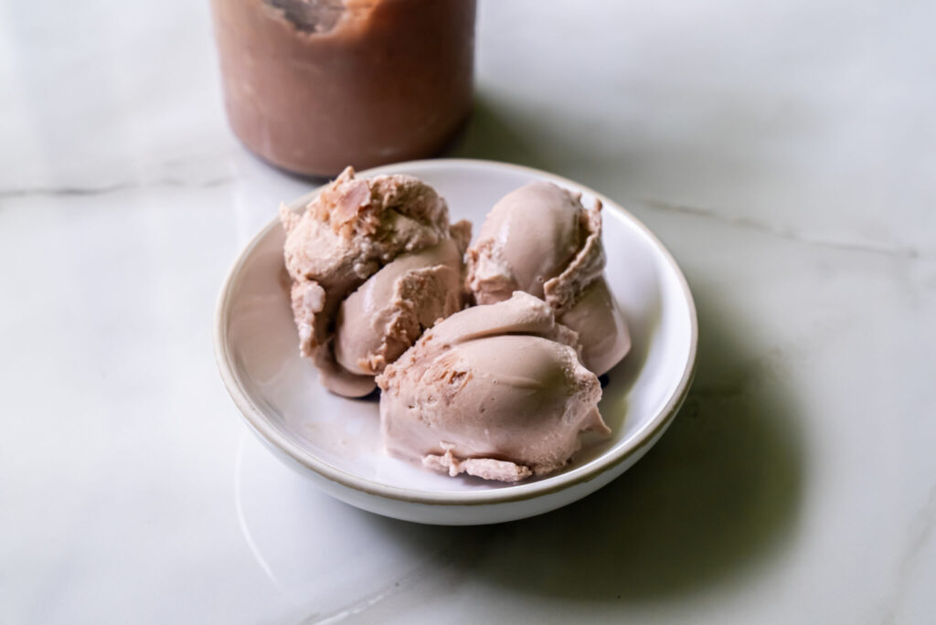 chocolate protein frozen yogurt in a white bowl.