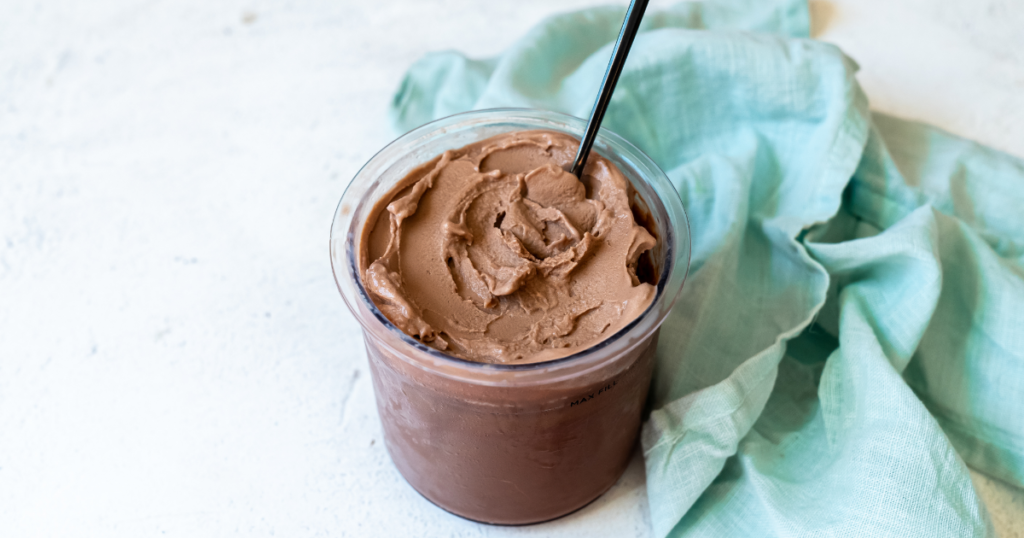 Chocolate Fairlife milk ice cream with spoon and a blue napkin