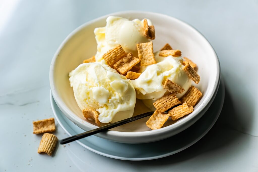 low carb banana protein ice cream with toppings and a spoon.