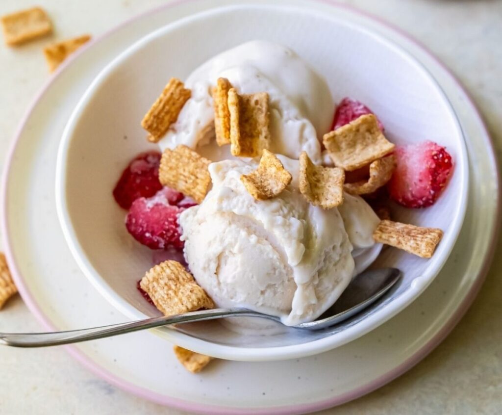 cheesecake protein ice cream topped with strawberries and cereal.