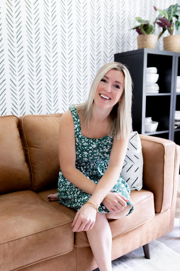 A girl sitting on an orange couch.