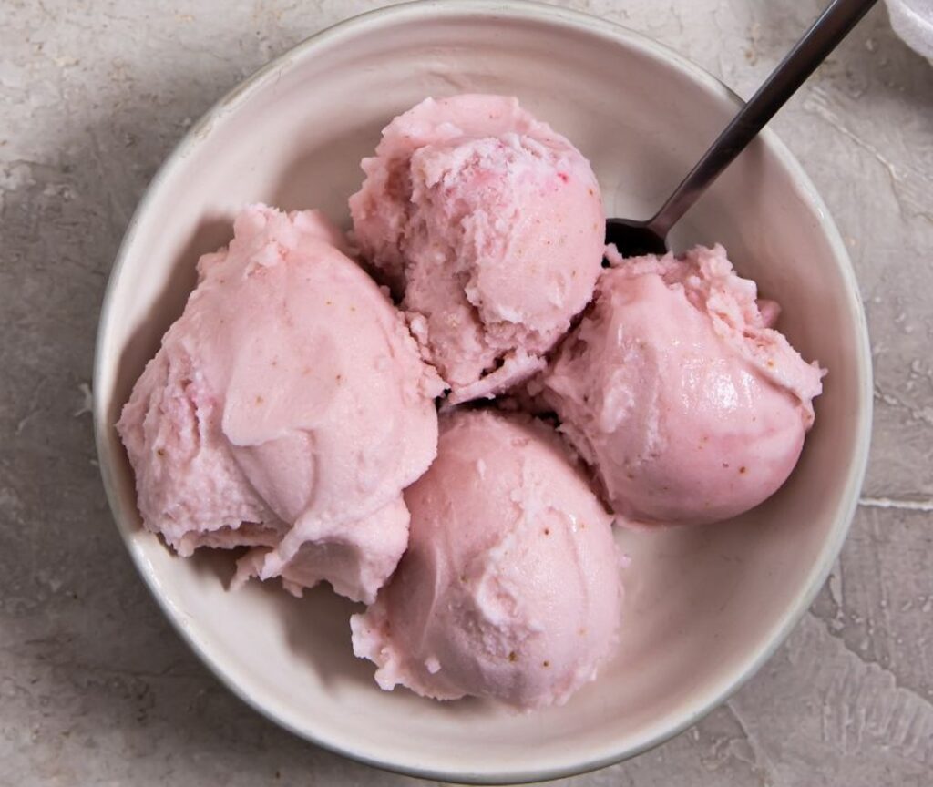 keto strawberry ice cream in a bowl with a spoon.