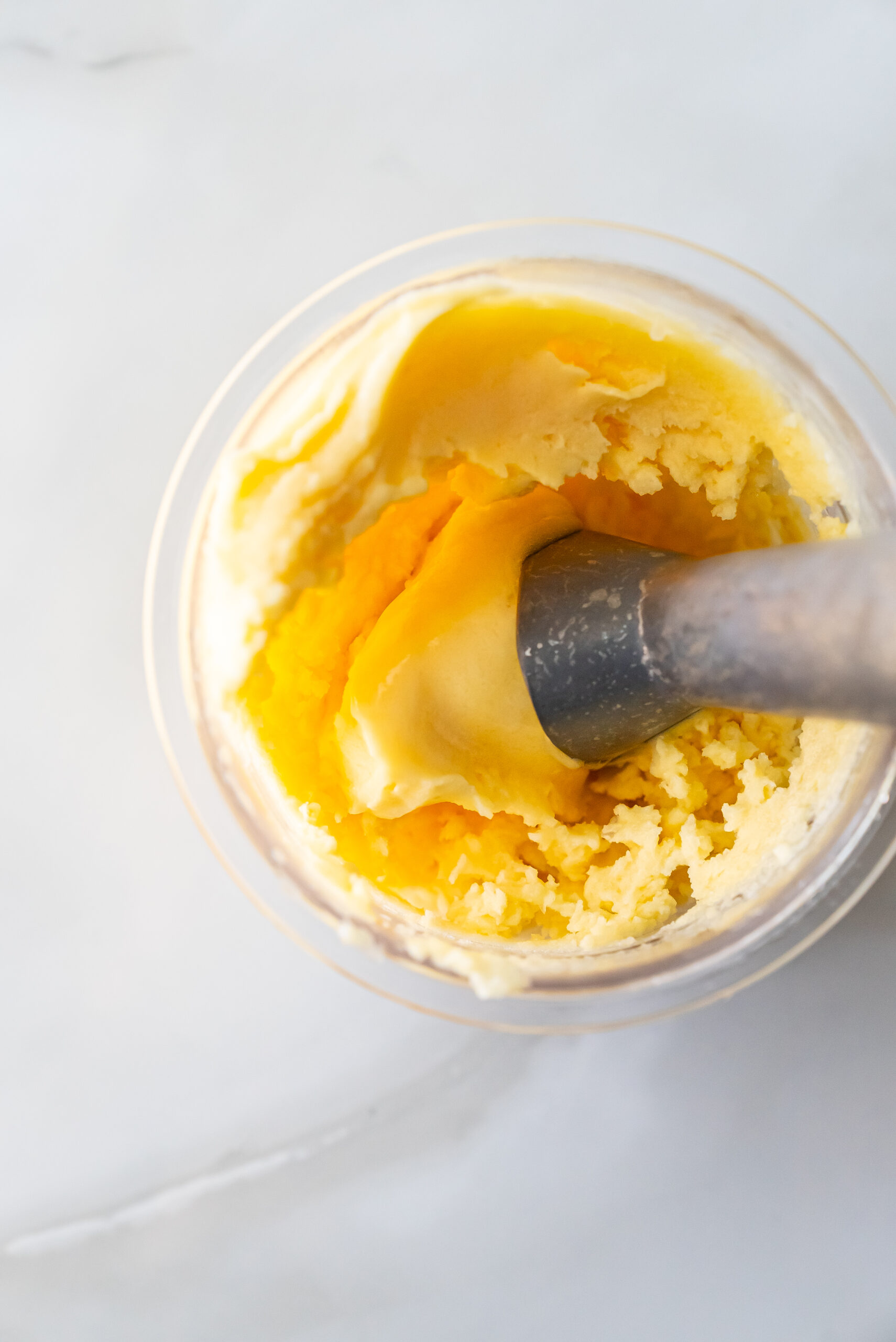 peach sorbet in a pint with a scooper.